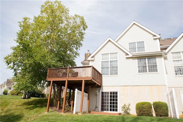 back of house with a deck and a yard