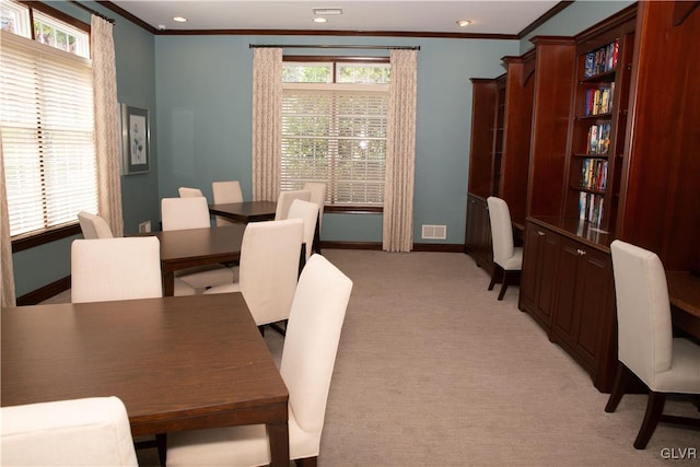 dining area featuring light carpet and crown molding