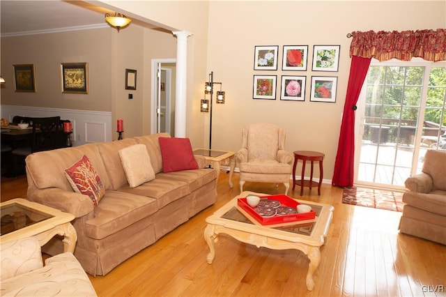 living room with hardwood / wood-style floors, ornate columns, and crown molding