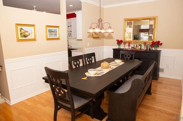 dining area with a chandelier, light hardwood / wood-style floors, and crown molding