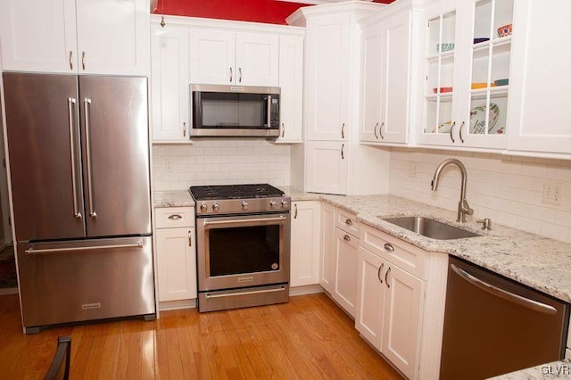 kitchen featuring white cabinetry, sink, stainless steel appliances, and light wood-type flooring