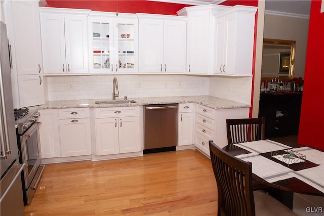 kitchen featuring sink, white cabinets, stainless steel appliances, and light hardwood / wood-style floors