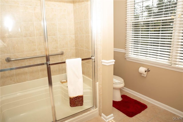 bathroom featuring tile patterned floors, toilet, and a shower with shower door