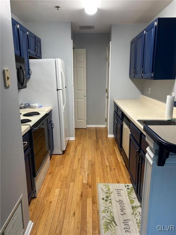 kitchen with blue cabinetry, light hardwood / wood-style floors, white range with electric cooktop, and sink