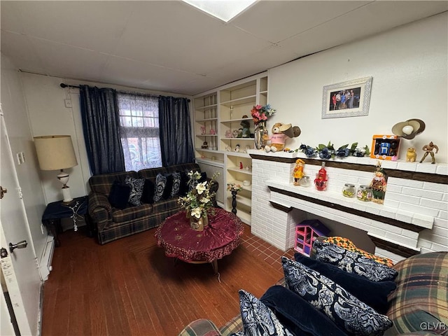 sitting room featuring built in shelves, hardwood / wood-style flooring, and a baseboard radiator