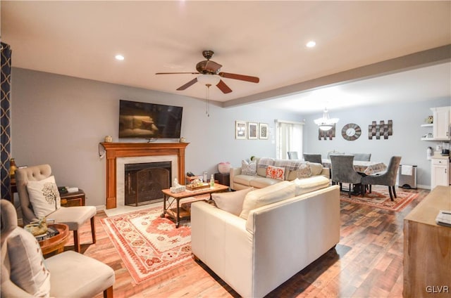 living room featuring hardwood / wood-style floors and ceiling fan with notable chandelier