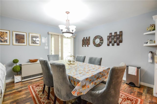 dining area featuring dark hardwood / wood-style flooring and a chandelier