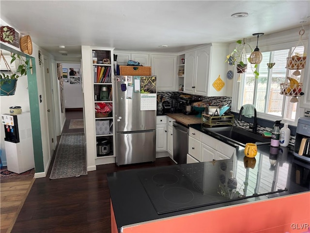 kitchen featuring white cabinets, decorative light fixtures, stainless steel appliances, and sink