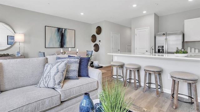 living room featuring sink and light hardwood / wood-style floors