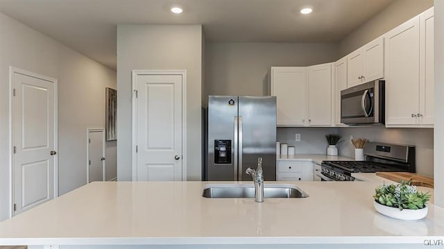 kitchen with kitchen peninsula, sink, white cabinets, and stainless steel appliances