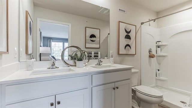 bathroom featuring vanity, toilet, and a shower