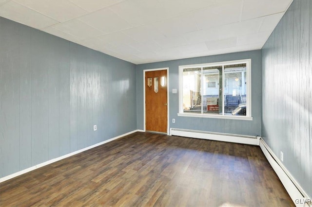 spare room featuring dark hardwood / wood-style flooring and a baseboard heating unit