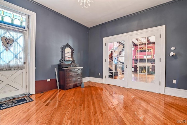 entrance foyer featuring hardwood / wood-style floors, ornamental molding, and french doors