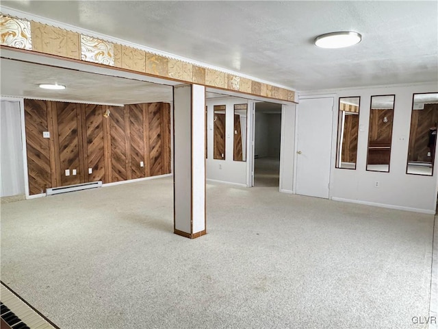 basement with carpet floors, baseboard heating, and wooden walls