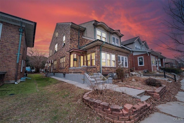 back house at dusk featuring a yard