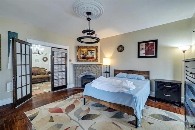 bedroom with a fireplace and dark hardwood / wood-style flooring