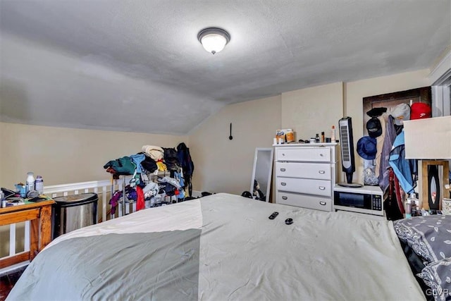 bedroom with lofted ceiling and a textured ceiling