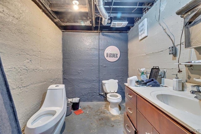 bathroom with vanity, toilet, and concrete floors