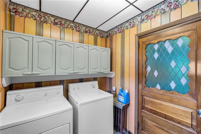 clothes washing area with cabinets and independent washer and dryer