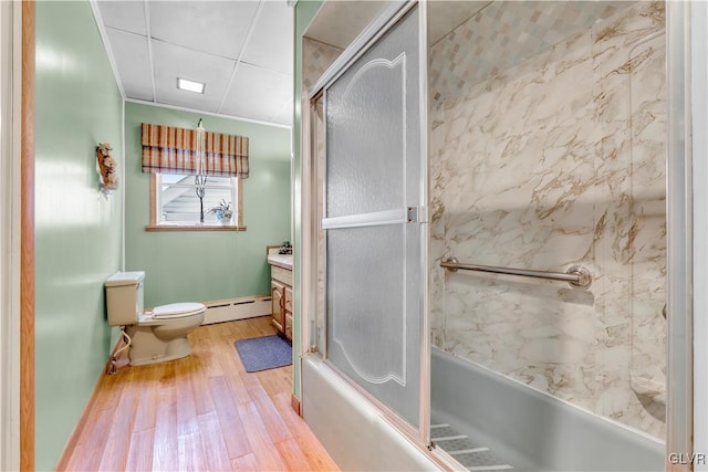 full bathroom featuring hardwood / wood-style floors, vanity, a baseboard heating unit, toilet, and enclosed tub / shower combo