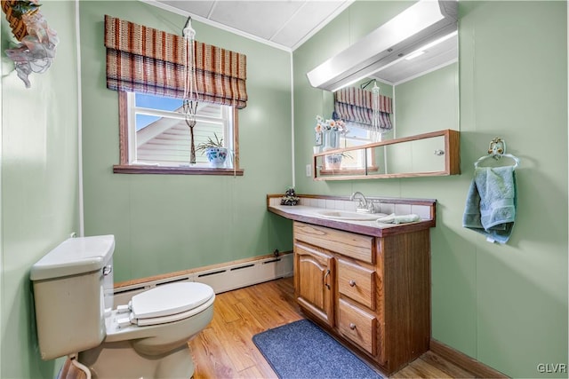 bathroom featuring hardwood / wood-style floors, ornamental molding, plenty of natural light, and a baseboard heating unit