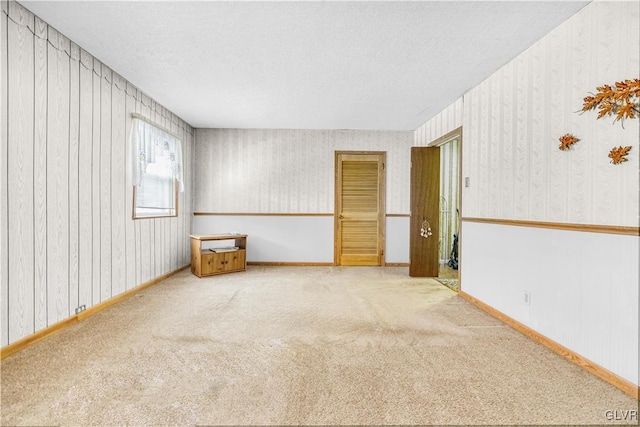 unfurnished room featuring carpet and a textured ceiling