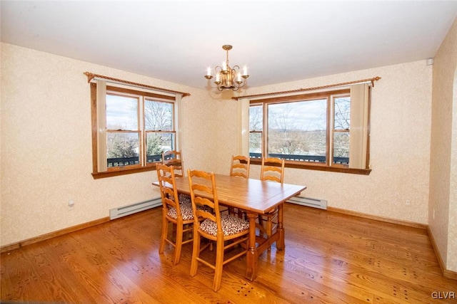 dining room featuring baseboard heating, hardwood / wood-style floors, and a notable chandelier