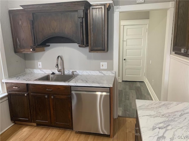 kitchen featuring dark brown cabinetry, light hardwood / wood-style floors, stainless steel dishwasher, and sink