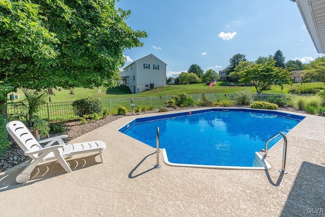 view of pool with a lawn and a patio