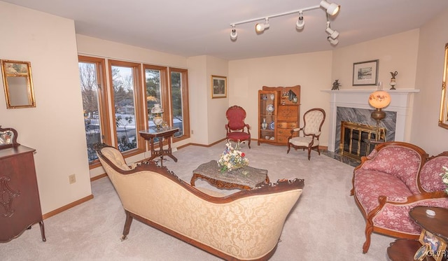 carpeted living room featuring track lighting and a premium fireplace