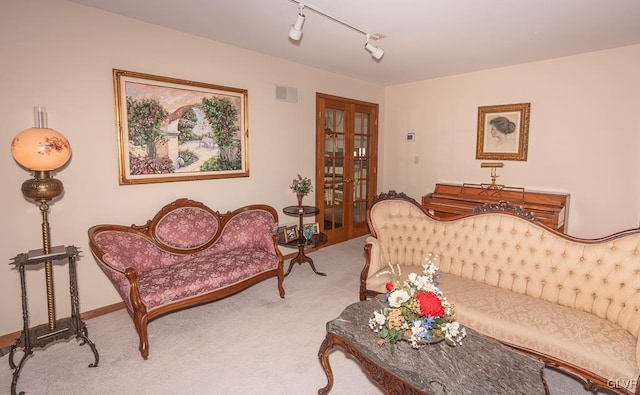 carpeted living room featuring french doors and rail lighting