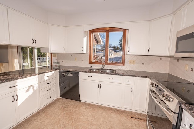 kitchen featuring dark stone countertops, sink, white cabinetry, and stainless steel appliances