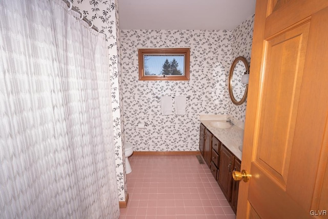 bathroom with toilet, vanity, and tile patterned floors