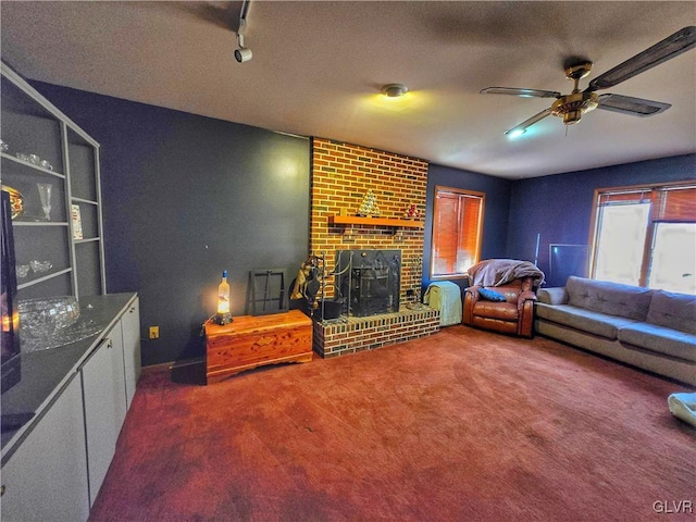 living room featuring a textured ceiling, carpet floors, a brick fireplace, and ceiling fan