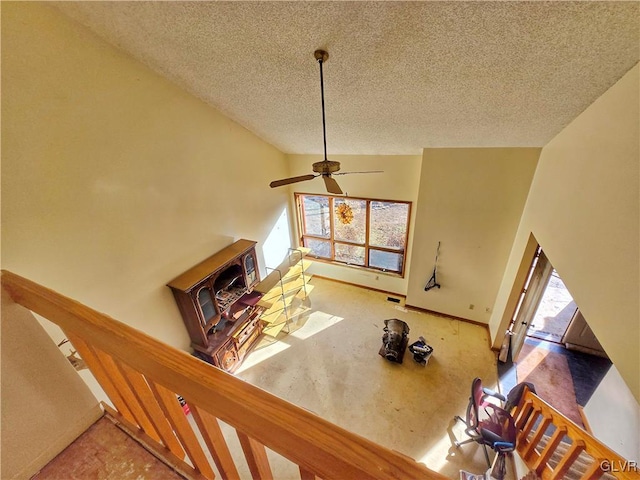 unfurnished living room featuring ceiling fan, a healthy amount of sunlight, and a textured ceiling