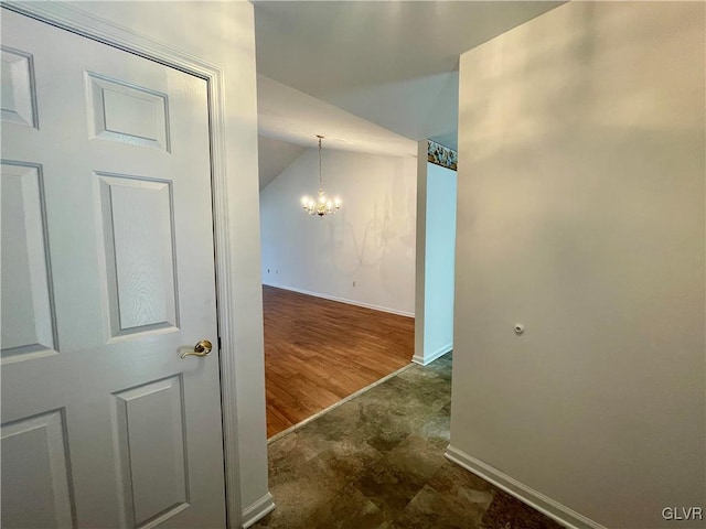 hallway featuring lofted ceiling and a notable chandelier