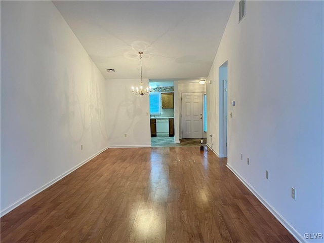 unfurnished living room with hardwood / wood-style flooring and a notable chandelier