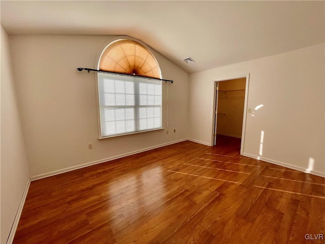 empty room with lofted ceiling and dark wood-type flooring