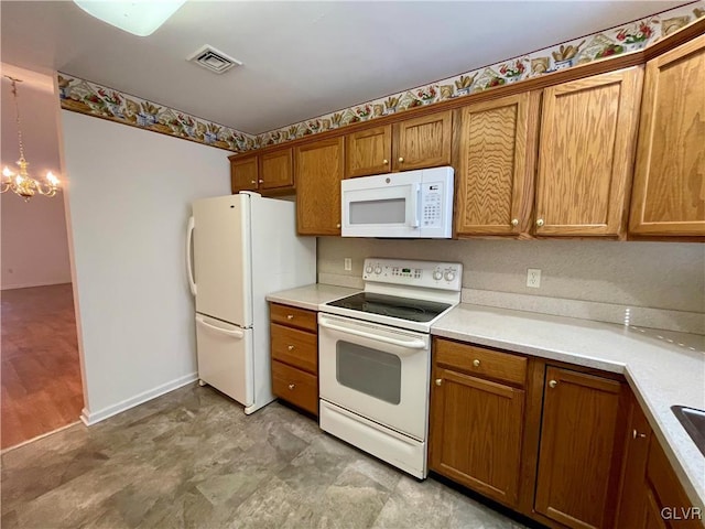 kitchen with pendant lighting, a notable chandelier, and white appliances