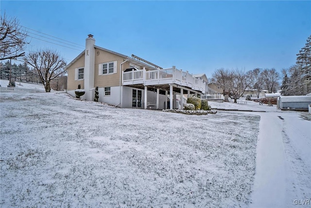 snow covered property with a deck