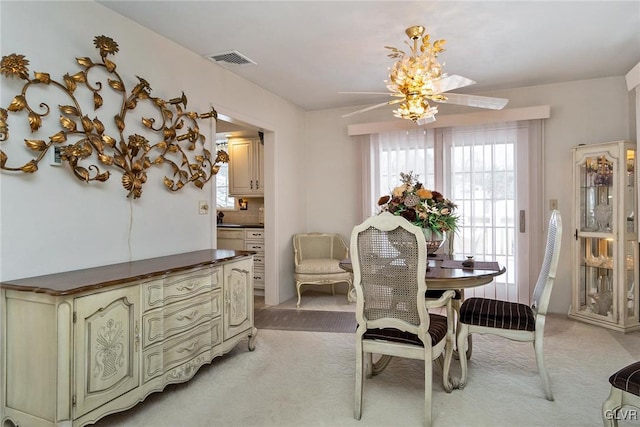 carpeted dining room with ceiling fan