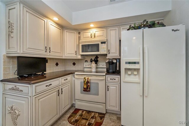 kitchen featuring white appliances, tasteful backsplash, and light tile patterned flooring