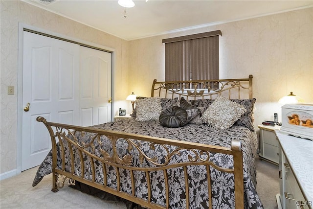 bedroom featuring light colored carpet and a closet