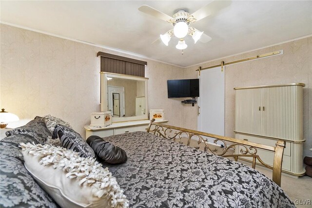 bedroom featuring carpet flooring, ceiling fan, a barn door, and ornamental molding