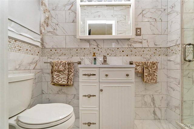 bathroom featuring vanity, toilet, and a shower with door