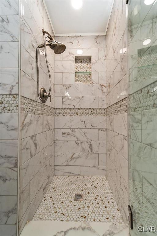 bathroom featuring an enclosed shower and ornamental molding