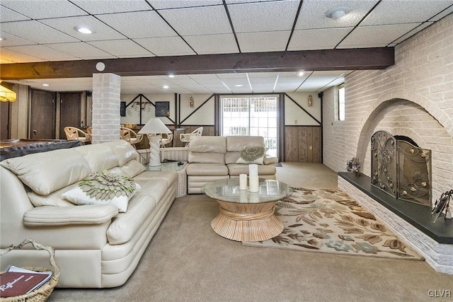 living room featuring wood walls, carpet floors, and decorative columns