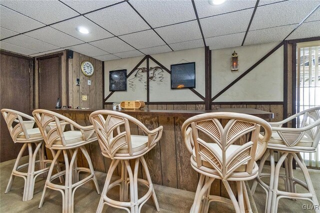 bar with a drop ceiling and wooden walls