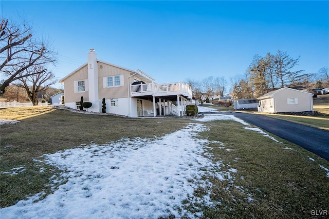 view of snow covered exterior featuring a yard and a deck