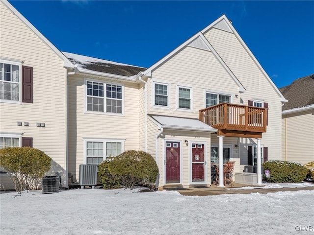 view of front of house featuring central AC unit and a balcony